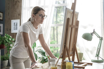 Woman looking at her artwork in the studio