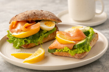 Sandwiches with smoked salmon, salad, cucumbers and eggs.