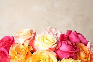 Luxury bouquet of fresh roses on beige background, closeup. Space for text