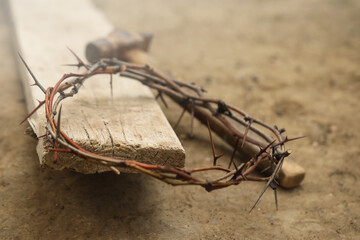 Fototapeta na wymiar Crown of thorns, hammer and wooden plank on ground. Easter attributes