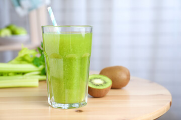 Glass of fresh celery juice on wooden table, closeup
