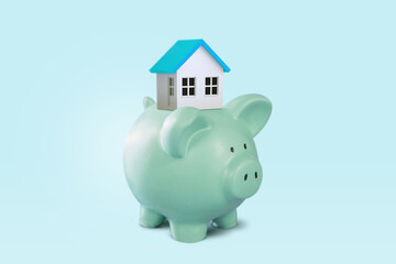 House and piggy bank on a blue background. The concept of accumulating money to buy a house