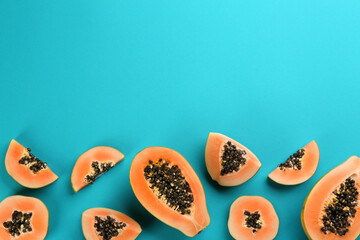 Fresh ripe papaya fruits on blue background, flat lay. Space for text