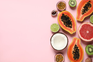 Obraz na płótnie Canvas Fresh ripe papaya and other fruits on pink background, flat lay. Space for text