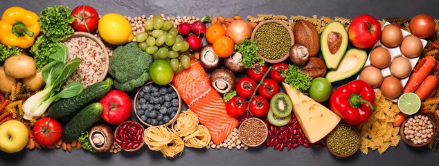 Foto op Canvas Verschillende producten op zwarte tafel, bovenaanzicht. Gezonde voeding en evenwichtige voeding © New Africa