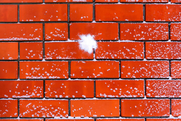 Snowball splat on the snowy brick wall.