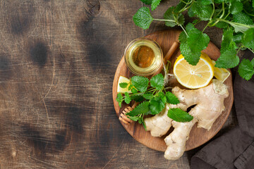 Ingredients for ginger tea with lemon, honey and mint. Lemon, ginger, honey and lemon balm on the table. Healthy food to boost immunity. Ingredients for ginger cookies with honey and mint. Top view  © Liudmila Zavialova