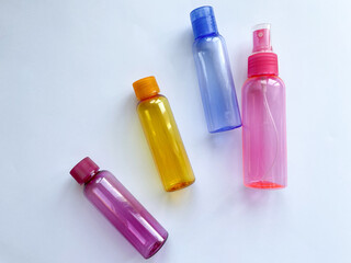 Colorful plastic travel bottles. Small containers for liquids like shower gel and shampoo. Face and body care products in compact size.