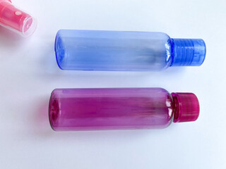 Colorful plastic travel bottles. Small containers for liquids like shower gel and shampoo. Face and body care products in compact size.