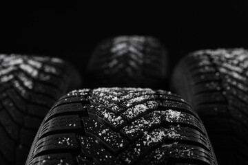 Set of new winter tires on black background, closeup © New Africa