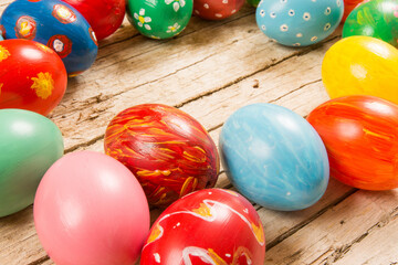 Easter background with handmade colored eggs on wooden table.