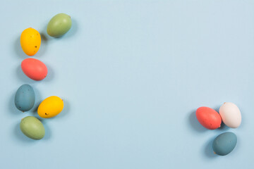 Easter background with handmade colored eggs on wooden a bright blue background. Frame and copy space.