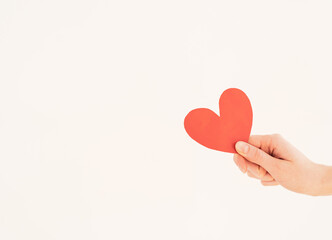 Red paper valentine in a woman's hand on a white background. Valentine's Day