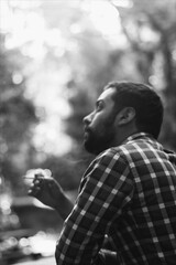 Young man in plaid smoking outside