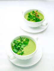 Green pea puree soup on white plate with place for text