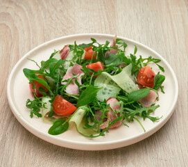 Green salad with arugula, tomato, bacon and feta cheese