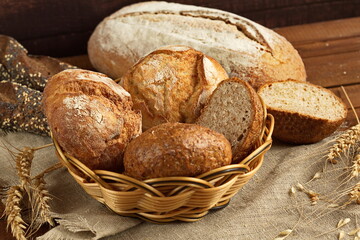Freshly baked bread of various shapes lies on a brown wooden surface.Copy space. Top view.