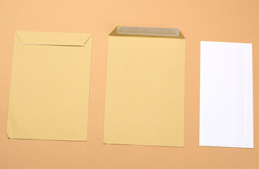 blank white paper brown and white envelopes on a brown background