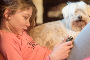 Pretty little girl playing or reading on a digital console or tablet
