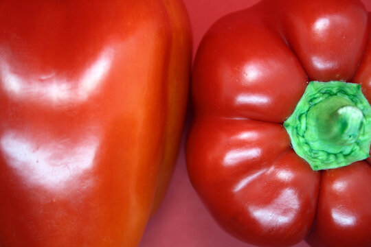 The fruit of a red sweet pepper on a red background.