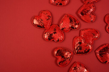 Fototapeta premium red textile small hearts on red background, festive background