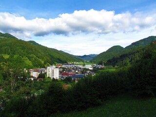 View of small town of Zelezniki in Selska dolina in Gorenjska region of Slovenia surrounded by forest covered hills © kato08