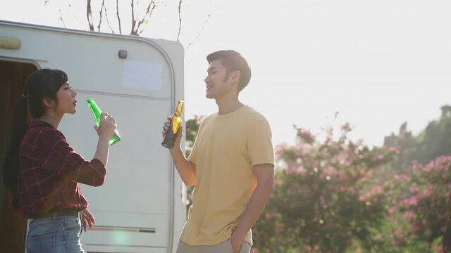 Young asian couple clinking and drinking beer together with happiness.