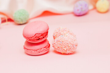 French pink macaroon cookies with Easter decorative eggs.
