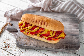 Hot dog with ketchup and mustard  for take away or food delivery on wooden background.
