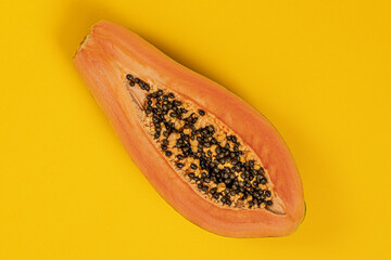 Ripe juicy half papaya cut on yellow background.Tropical nature fruits summer concept.