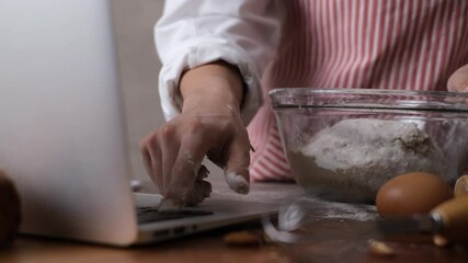 Woman kneeding dough to make bakery by learning form video online class. Learning baking concept.