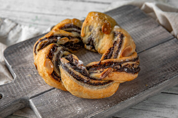 Puff pastry pretzel bun stuffed with apples, poppy seeds and jam. Bakery products. Sweet pastry.