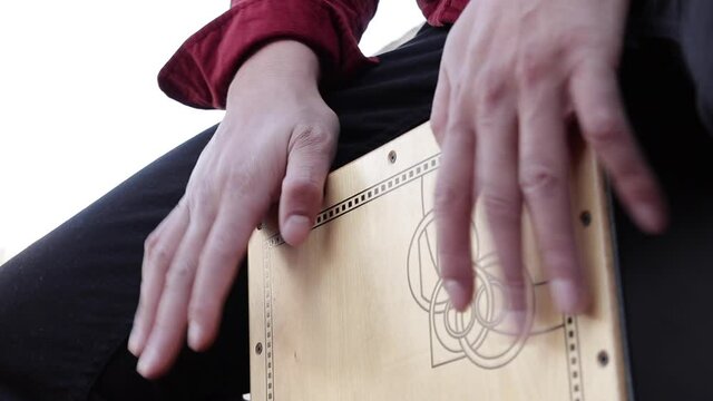 a percussionist playing the flamenco cajon instrument.