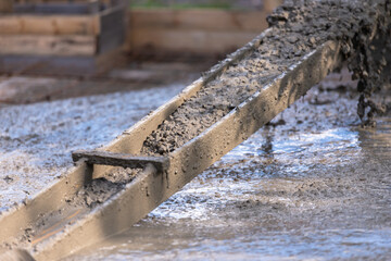 Fototapeta premium Self-made chute for concreting works. Concrete pours down a wooden chute
