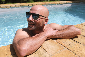 handsome guy half-naked cheerful man smiling laughing in blue water swimming pool