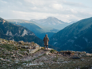 Back view of a man in warm clothes in the mountains in nature