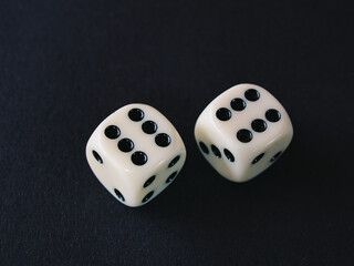 Close-up of two white dice against black background. Dice show double six