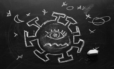 Virus doodle emoji with face drawn using chalk on black chalkboard, blackboard background and texture, covid awareness concept