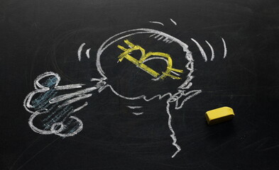 Bitcoin cryptocurrency symbol depicted as deflating popped balloon, falling stocks drawn on black chalkboard with yellow colorful chalk, blackboard background texture