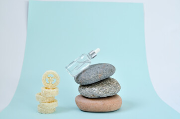 Cosmetic serum in white dropper bottles on natural stone. Blue background, natural skincare products concept.