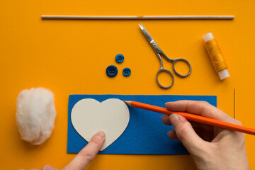 Step2, making a valentine from blue felt with your own hands (DIY): circle the heart template twice on the felt.