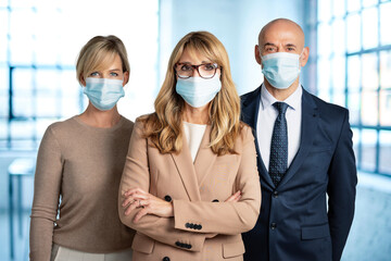 Fototapeta na wymiar Group of business peoples wearing face mask while standing together in the office