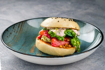 avocado burger with salted salmon and fresh vegetables. Healthy raw food, avocado burger with raw salmon and guacamole