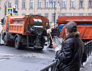 Fototapeta premium a man in warm clothes with a toilet brush in his hand stands on a partitioned city street. Rally in St. Petersburg, Russia, January 31, 2021 man with a brush in the city center