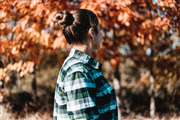 Young woman in plaid from behind autumn weather