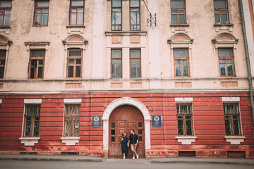 Fototapeta na wymiar Happy beautiful young couple on the background of red old doors. Happy family concept