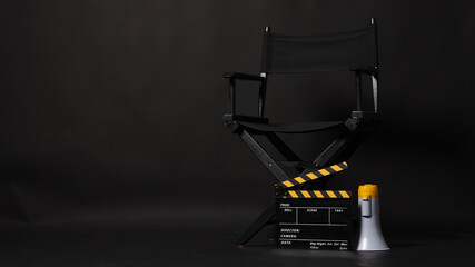 Black Director chair and yellow clapper board or Clapperboard or movie slate with megaphone .it use...