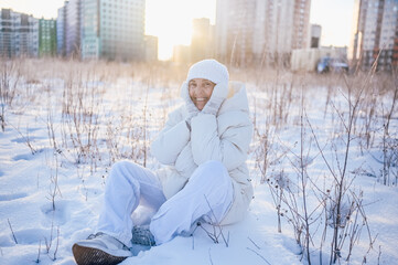 Happy elderly senior mature woman in white warm outwear playing with snow in sunny winter outdoors. Retired healthy people holiday vacation winter activities, active lifestyle concept.