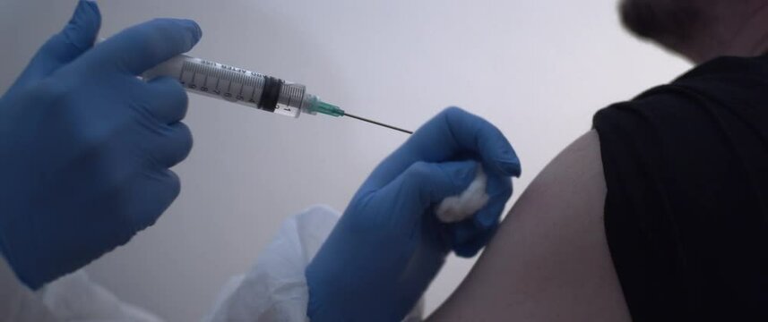 Man's arm being injected Vaccine