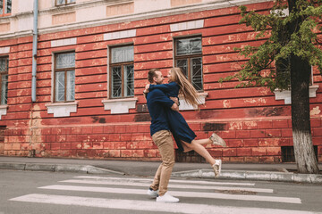 Fototapeta na wymiar Happy couple walking on the crosswalk in the city